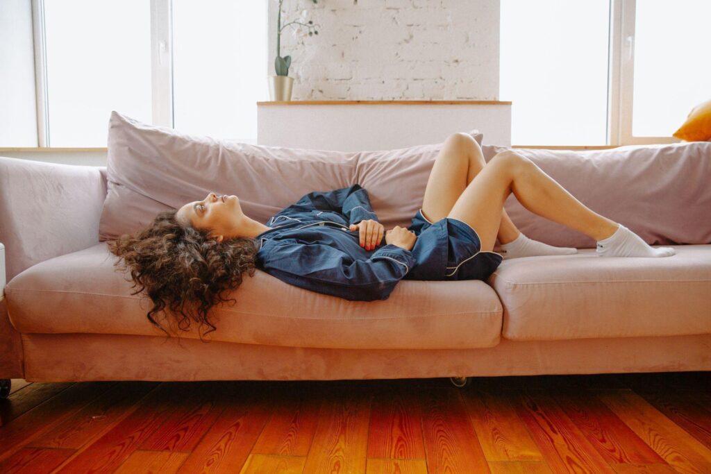 a woman on a sofa having a stomachache